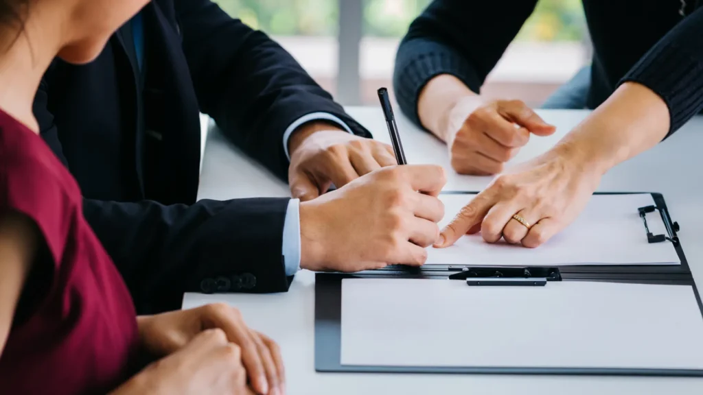 Kadın ile erkek avukat eşliğinde boşanma evrakalrını imzalıyor.