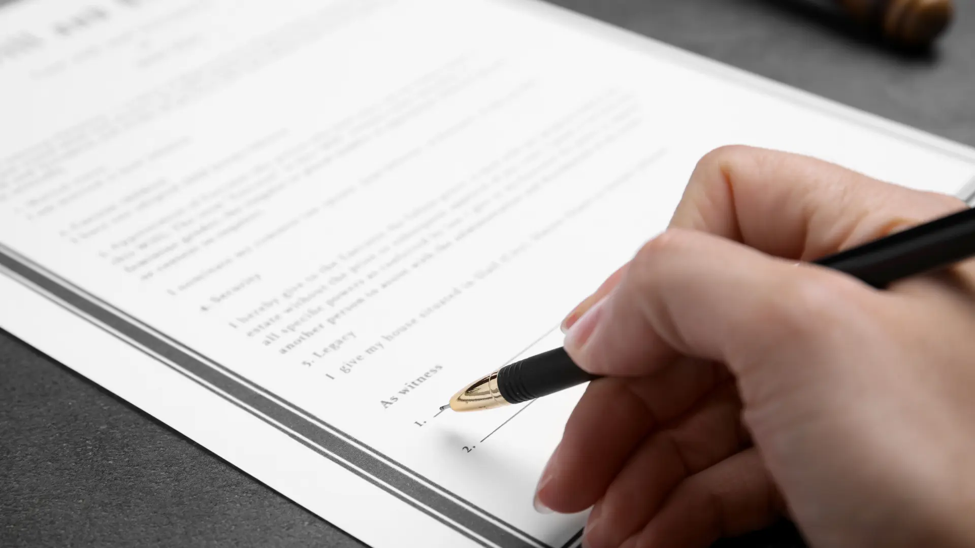 Bir kişi elinde kalem ile bir evrağa imza atıyor