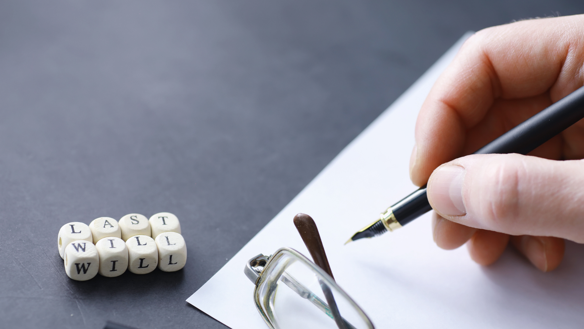 Bir kişi elinde kalem ile boş bir kağıda birşeyler yazıyor