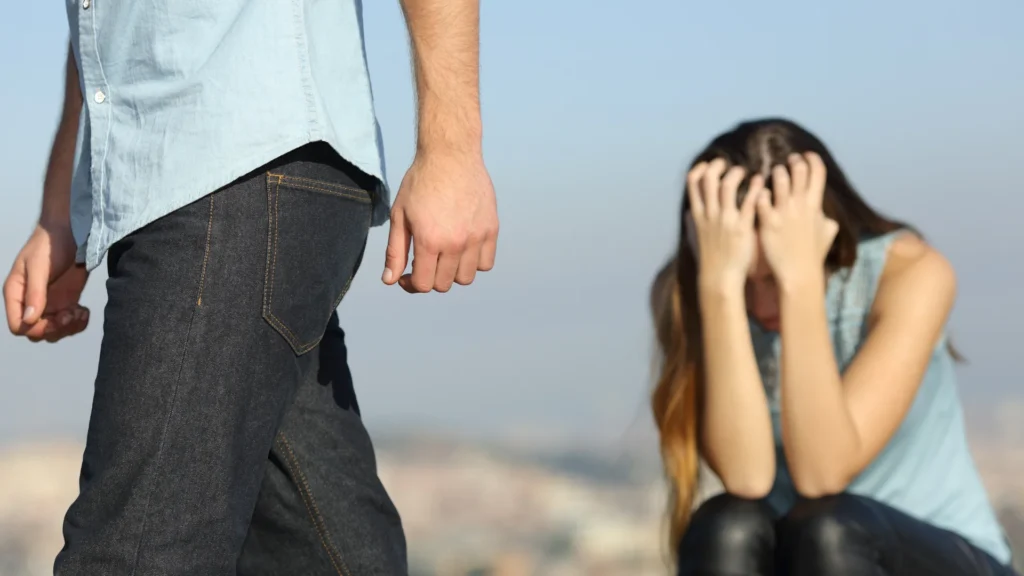 Kadın ellerinya yüzünü kapatmış şekilde oturuyor erkek ise aya kalmış kadının yanından ayrılıyor