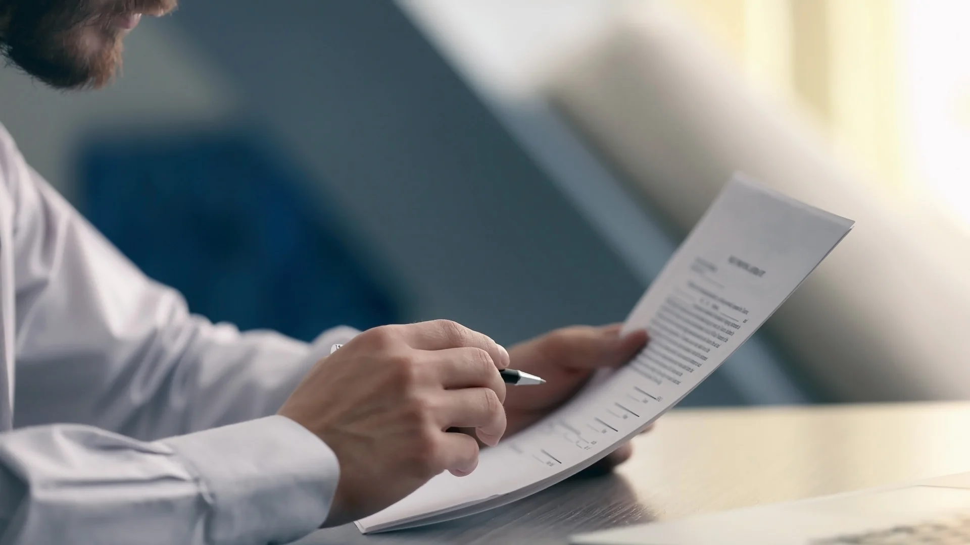 Bir kişi elindeki evrağı inceliyor