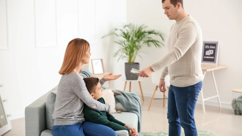 kadın bir eliyle çocuğa sarılmış diğer eliyle erkein verdiği parayı alıyor